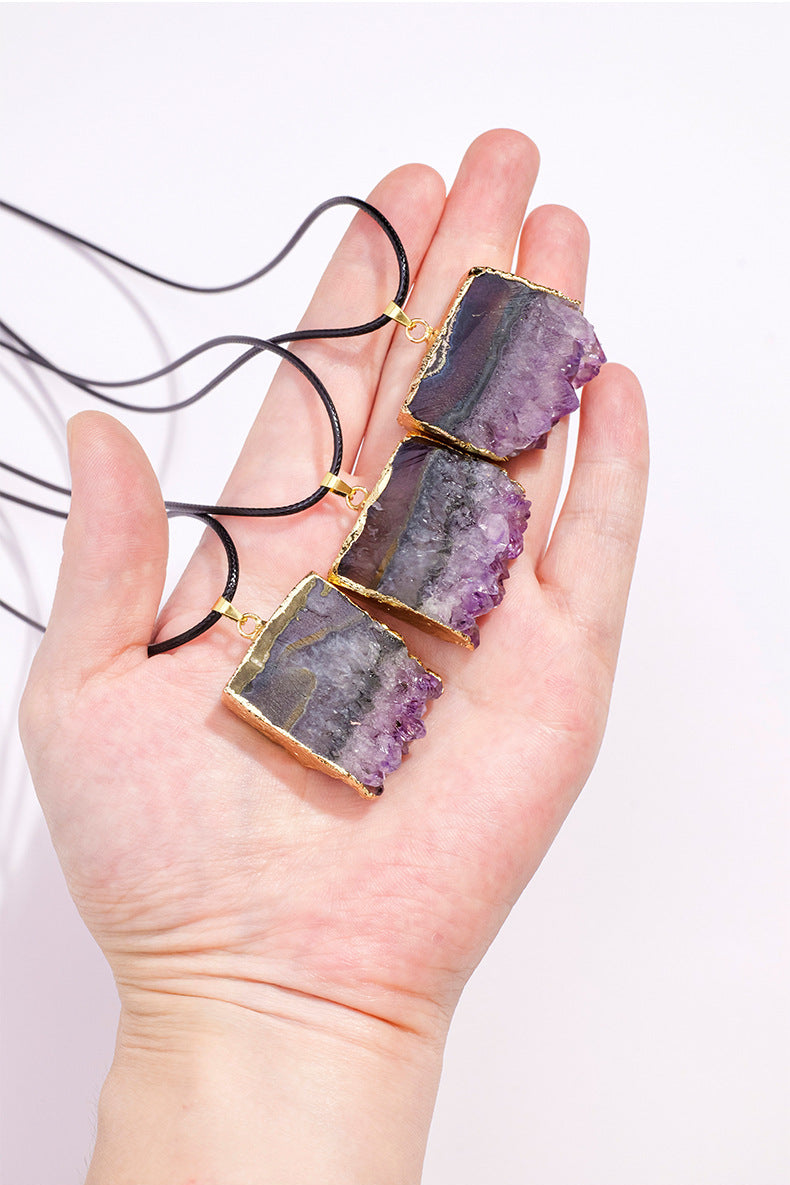 Amethyst cluster pendants shown in a hand for scale — exact supplier photo cropped to remove marketing copy